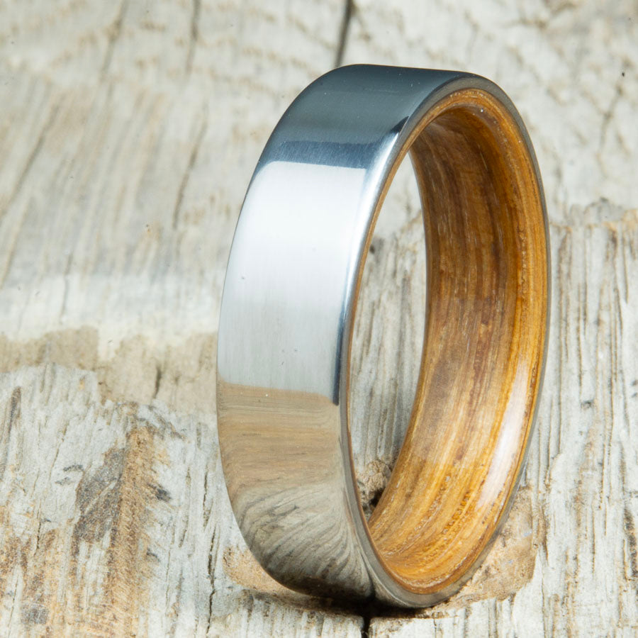 Classic titanium wedding band with Jack Daniels whiskey barrel wood interior. Unique titanium wood rings made by Peacefield Titanium.