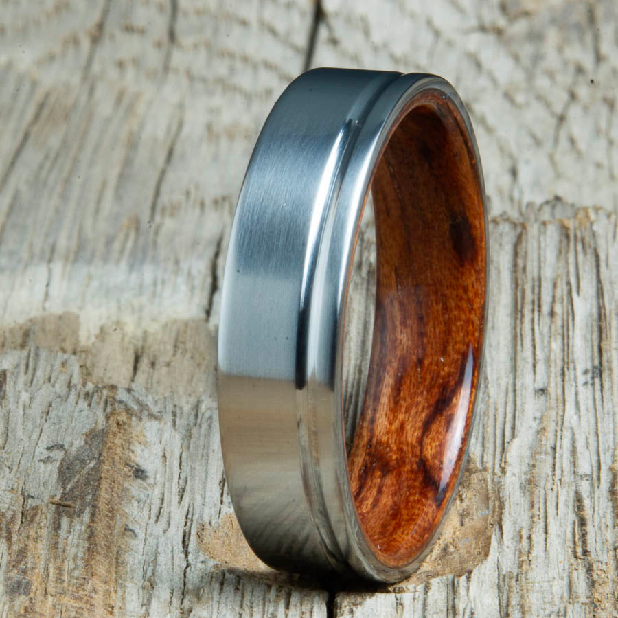 Single groove satin titanium wood ring with Bubinga wood interior. Custom titanium wood rings handcrafted by Peacefield Titanium