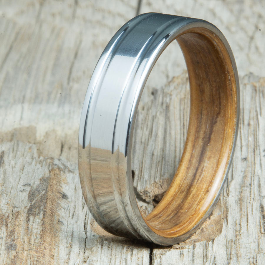 Double grooved titanium ring with whiskey barrel wood interior. Custom whiskey barrel wedding bands made by Peacefield Titanium