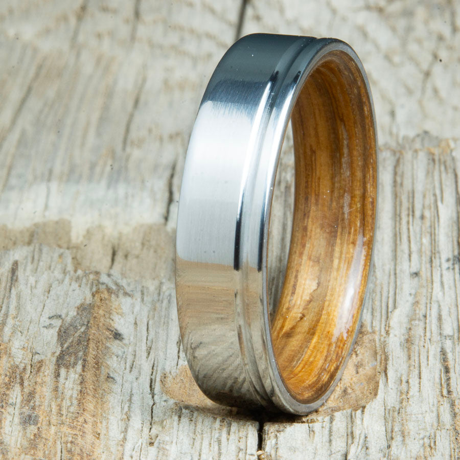 bentwood Jack Daniels whiskey barrel wood ring with polished titanium and single offset groove. Unique bentwood wedding bands made by Peacefield Titanium.