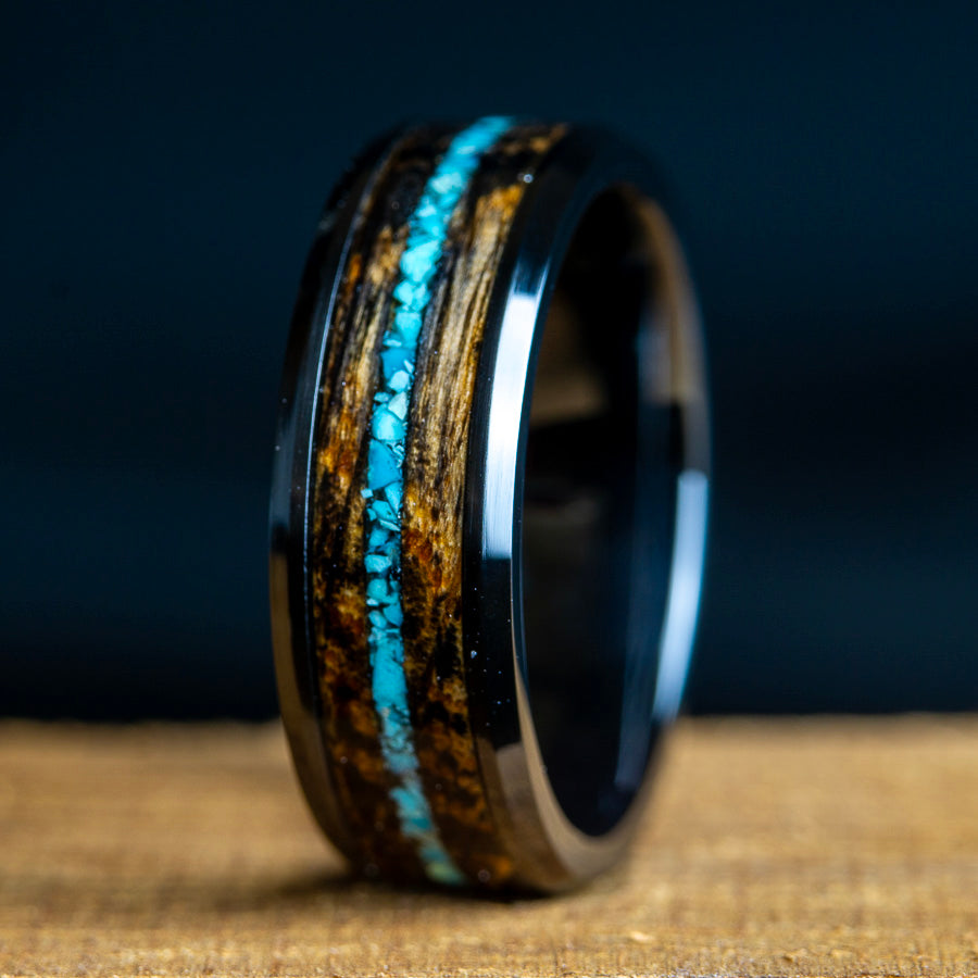 Ring with wooden and turquoise inlay on a dark background