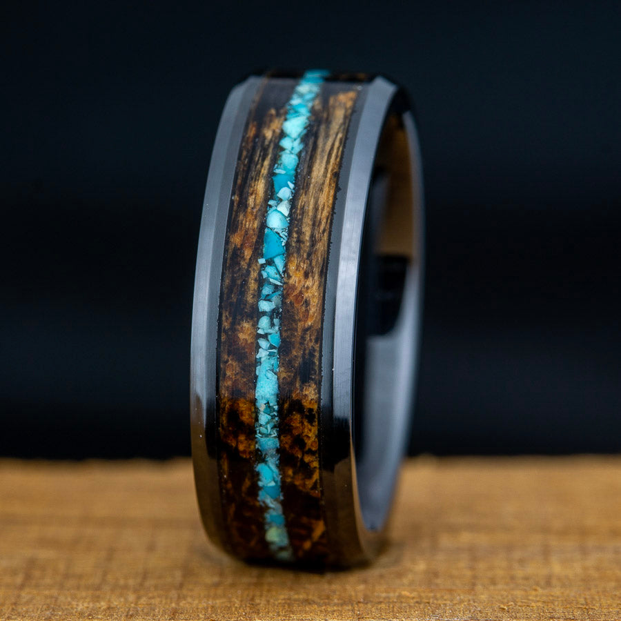 Wooden ring with turquoise inlay on a dark background