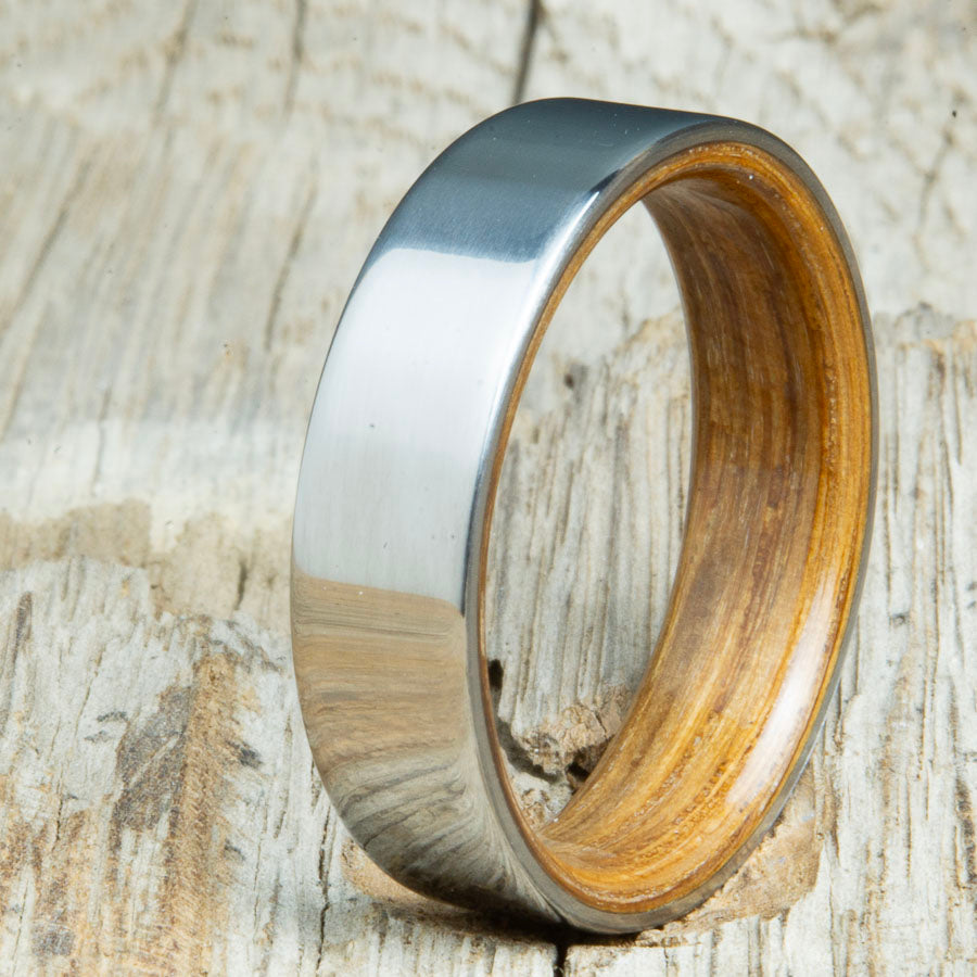 Classic mens Whiskey barrel wood wedding band with polished titanium. Custom wood rings made by Peacefield Titanium