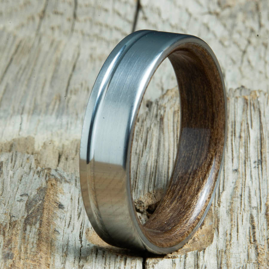 Single groove satin titanium wood ring with Walnut wood interior. Custom titanium wood rings handcrafted by Peacefield Titanium