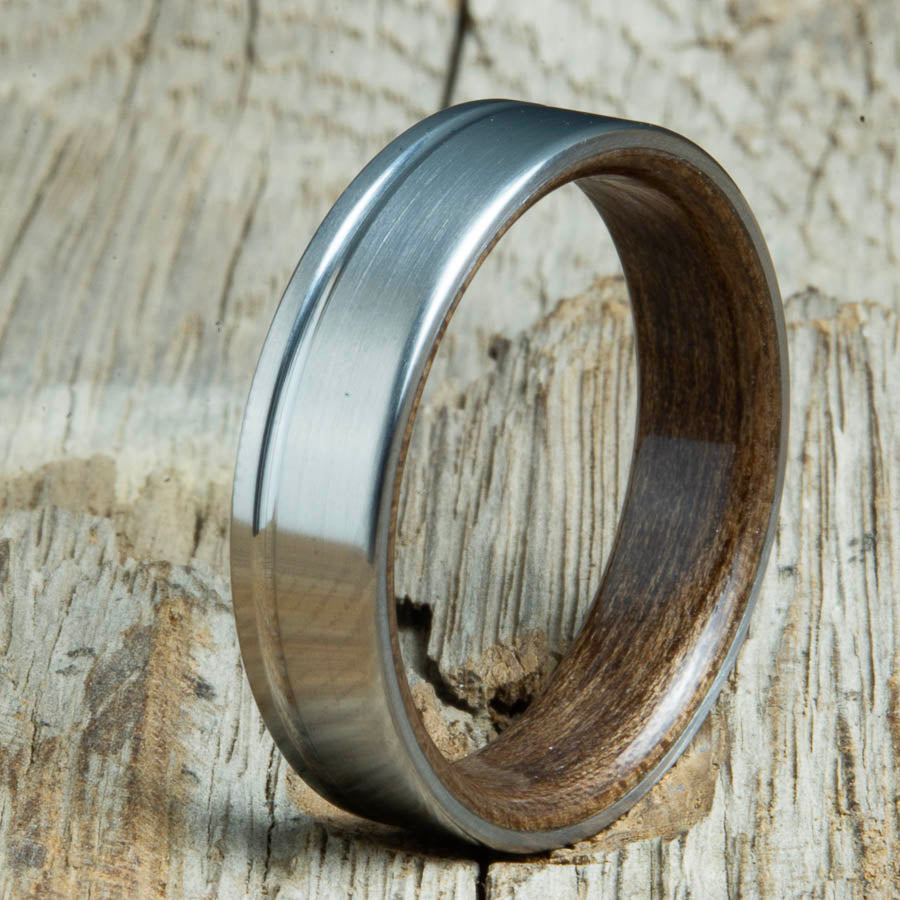 Single groove satin titanium wood ring with Walnut wood interior. Custom titanium wood rings handcrafted by Peacefield Titanium