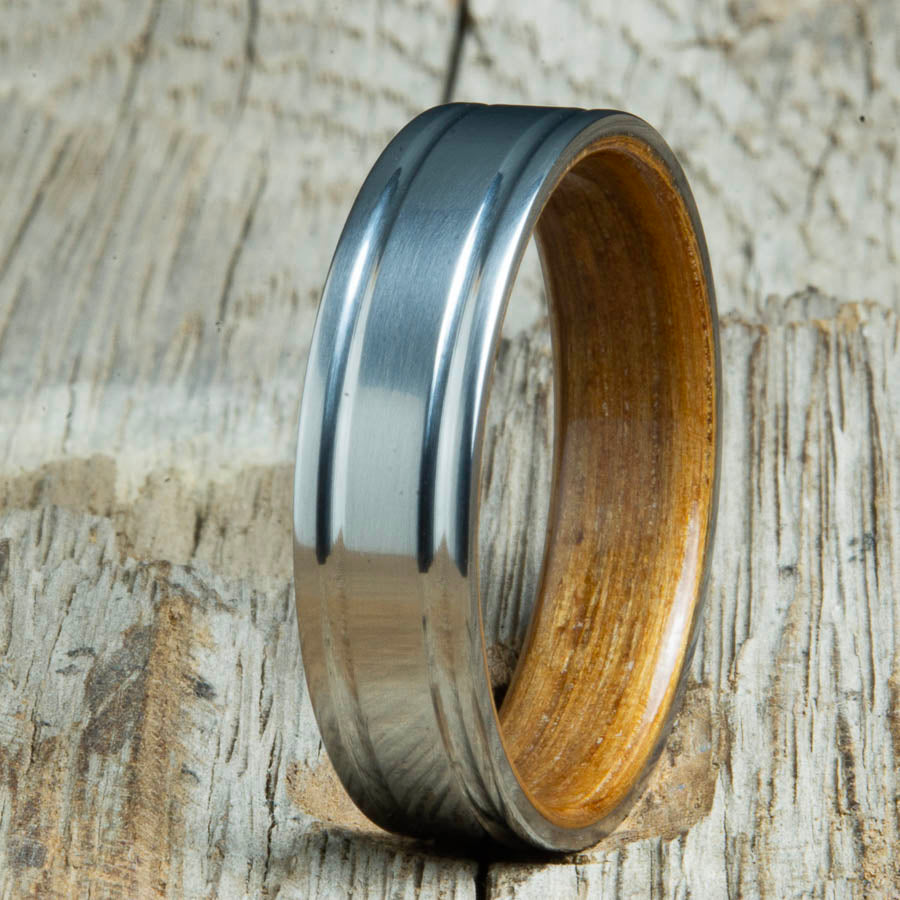 Double groove satin titanium wood ring with Whiskey barrel wood interior. Unique handcrafted wedding rings made by Peacefield Titanium