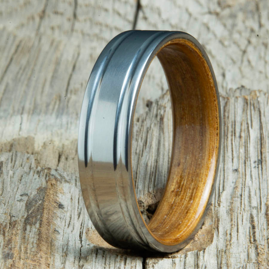Double groove satin titanium wood ring with Whiskey barrel wood interior. Unique handcrafted wedding rings made by Peacefield Titanium