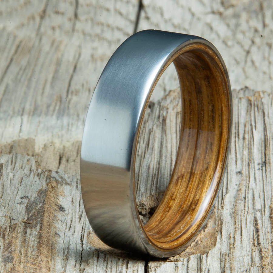 classic satin titanium with Whiskey barrel wood interior ring. Custom titanium wood rings made by Peacefield Titanium