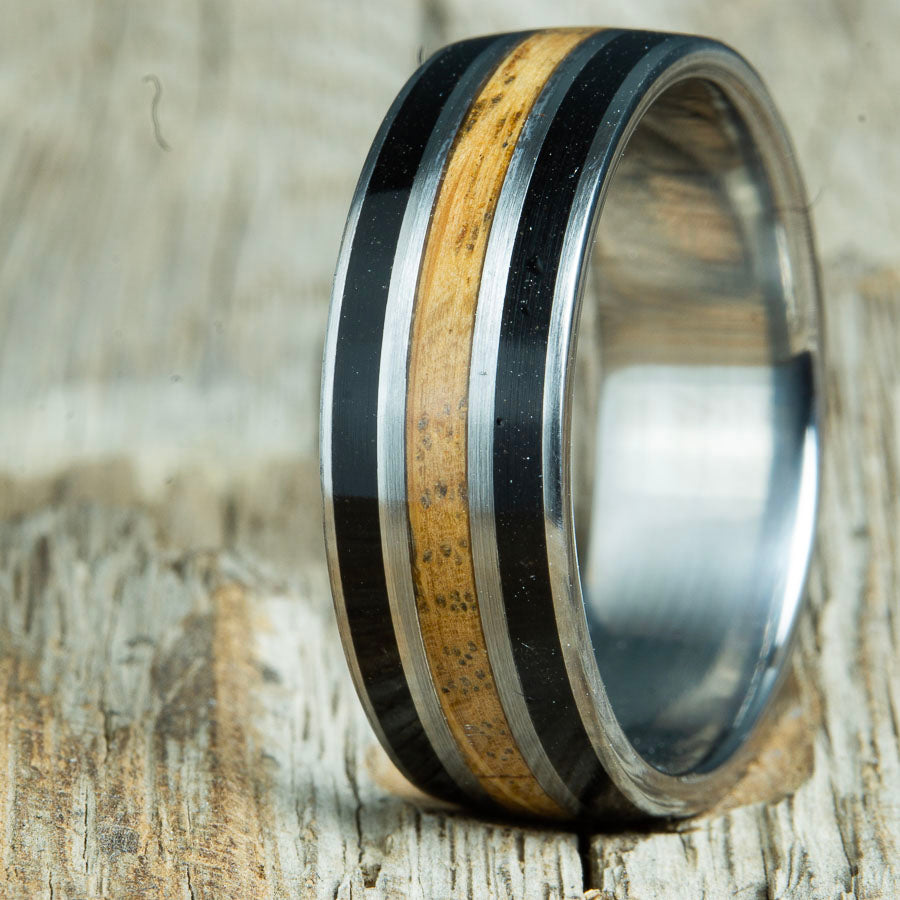 whiskey barrel wood inlay ring with volcanic sand. Custom made wood and titanium ring made by Peacefield Titanium.