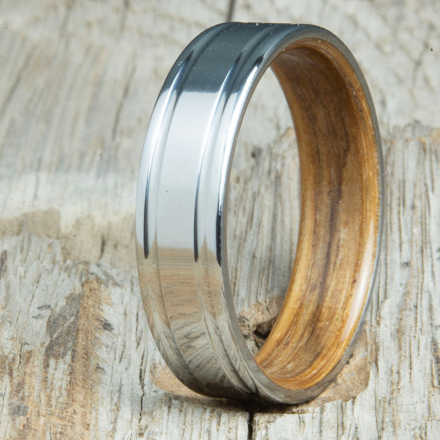 Double grooved titanium ring with whiskey barrel wood interior. Custom whiskey barrel wedding bands made by Peacefield Titanium
