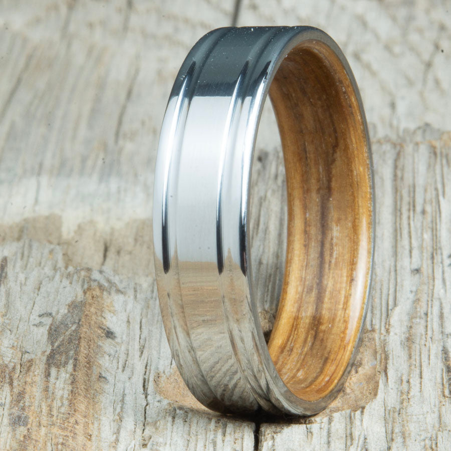 Double grooved titanium ring with whiskey barrel wood interior. Custom whiskey barrel wedding bands made by Peacefield Titanium