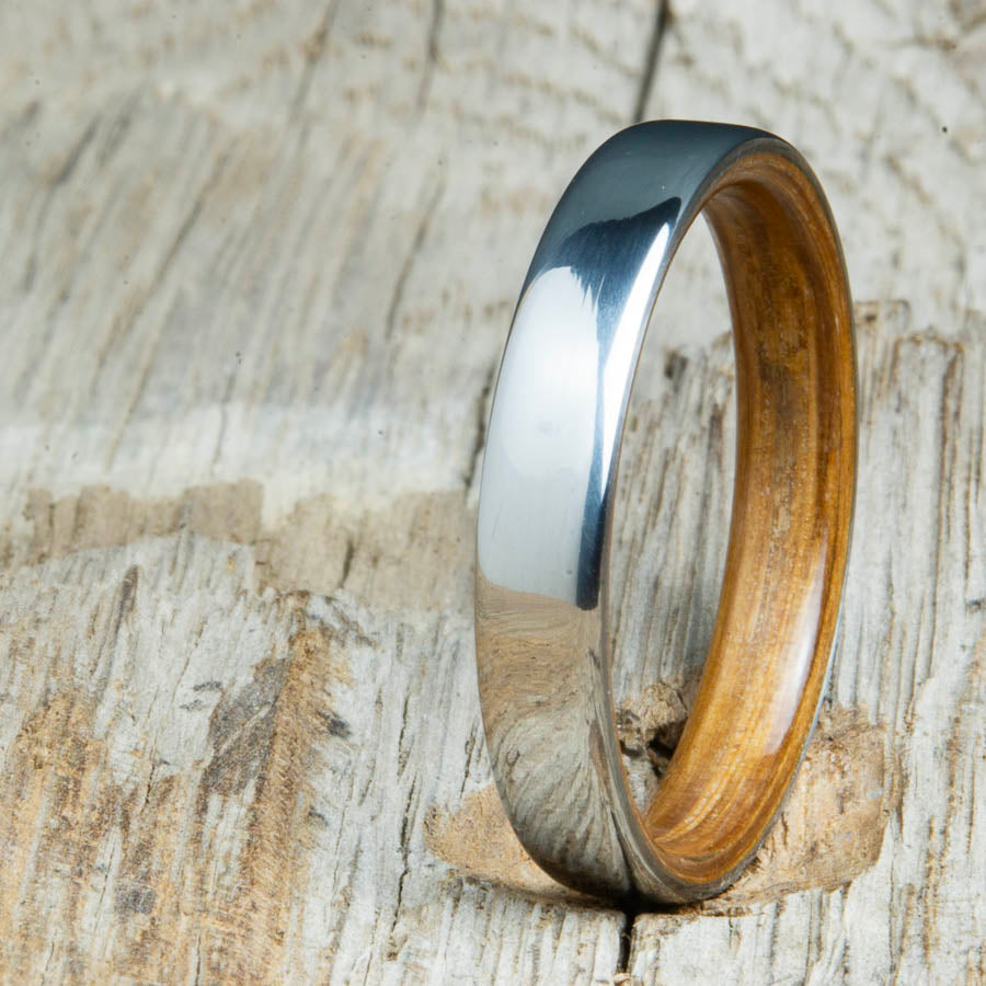 Classic domed womens wood wedding band with Whiskey barrel wood. Unique wooden rings for women made by Peacefield Titanium.